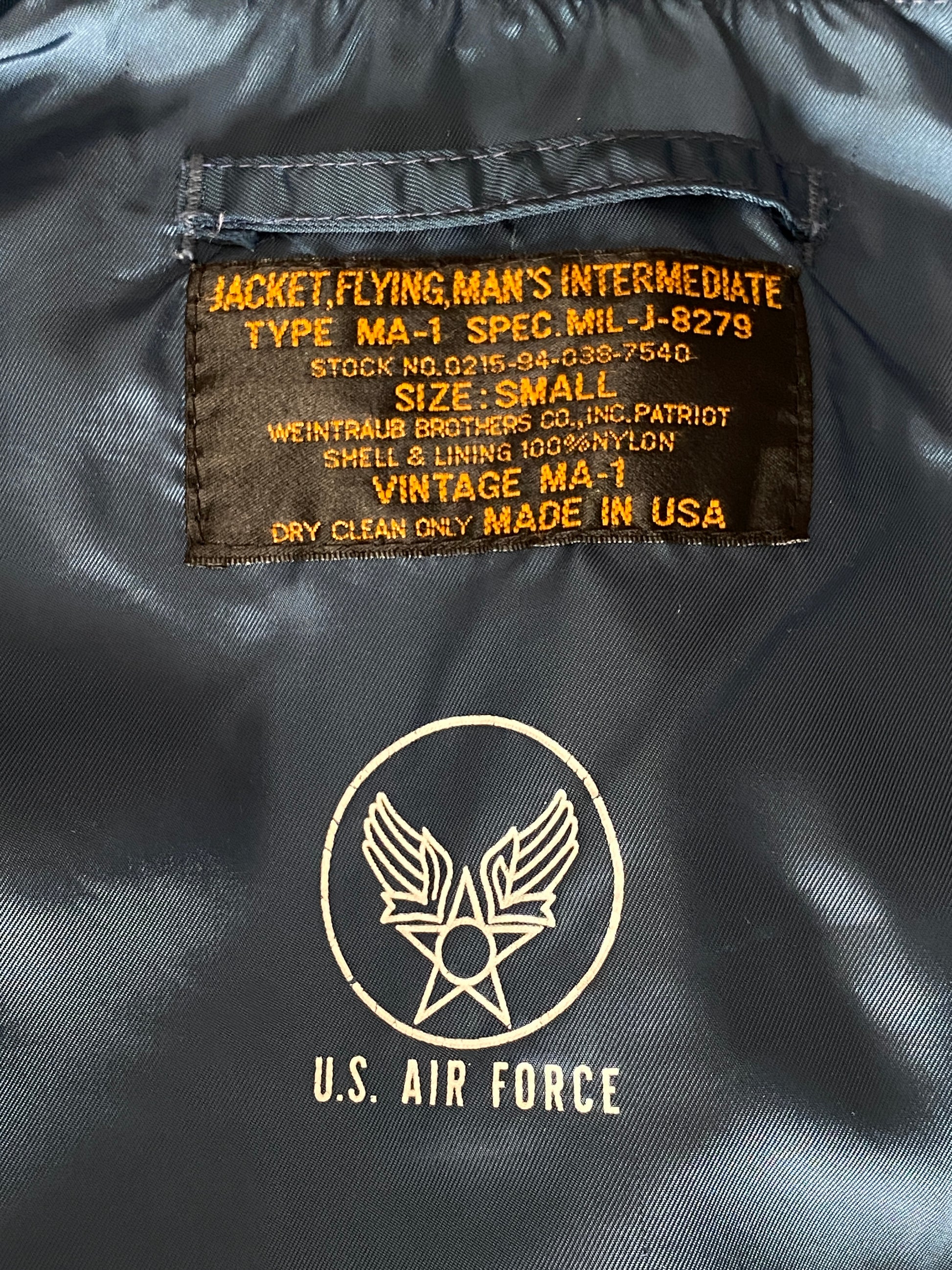 Vintage MA-1 flight bomber jacket by Weintraub Brothers, nylon shell with orange lining, size Small.