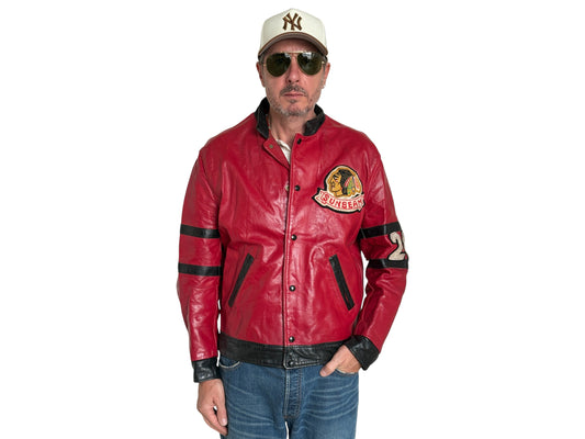 Man wearing a red leather jacket with a logo, sunglasses, and a cap on a white background