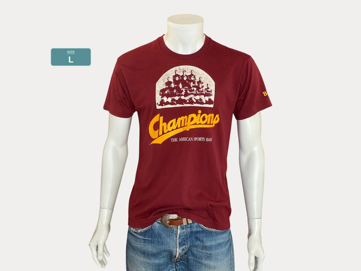 Grand. T-shirt vintage 50/50 coton des années 80, Champions Sports Bar, fabriqué aux États-Unis.