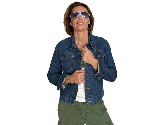 Woman wearing a blue denim jacket and green pants on a white background